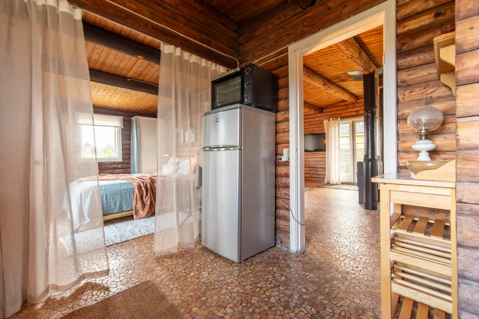 Flur mit Kühlschrank, durch die Tür das Schlafzimmer