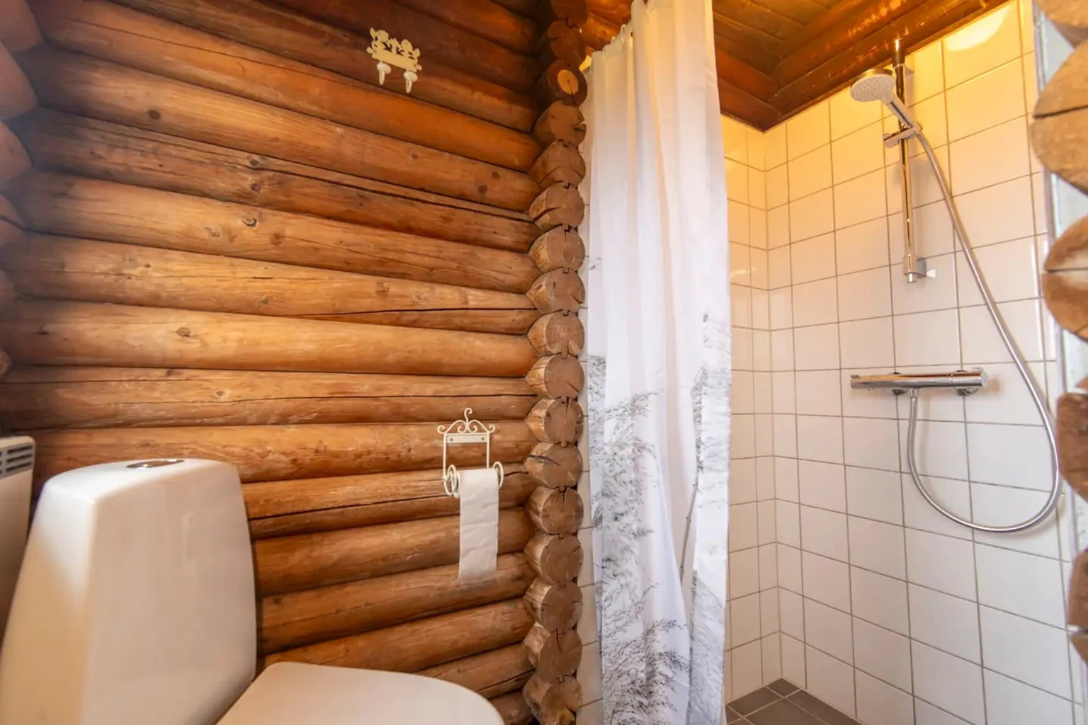 Dusche und WC mit weißen Fliesen