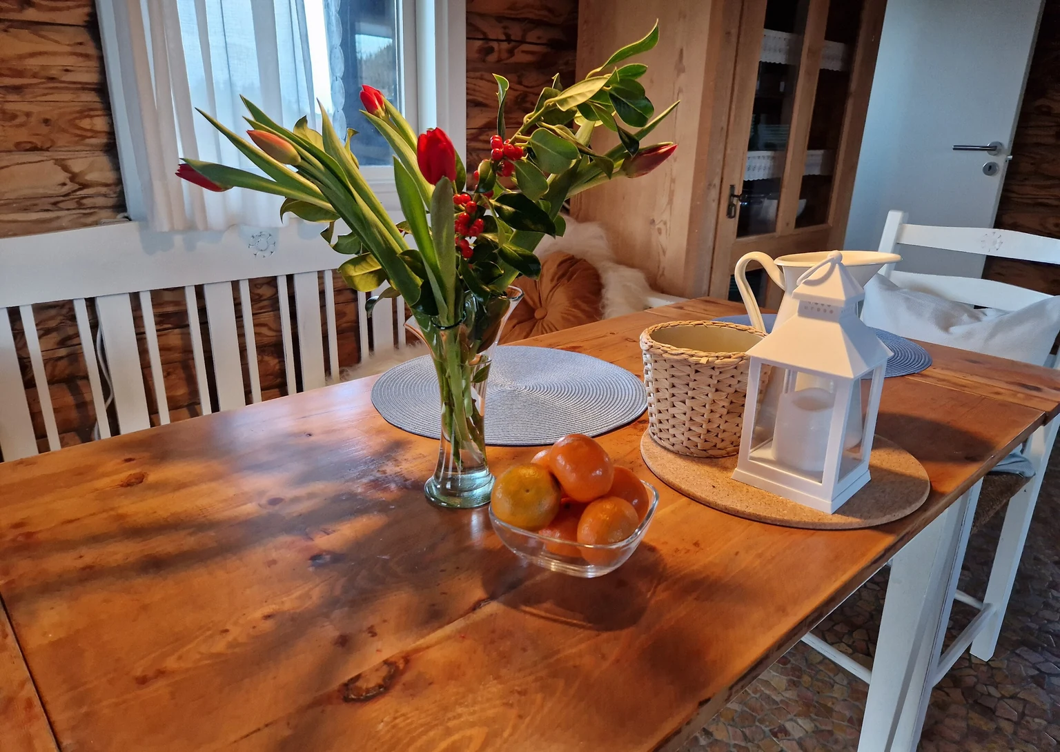 Tisch mit Tulpen, Obstschale und Laterne