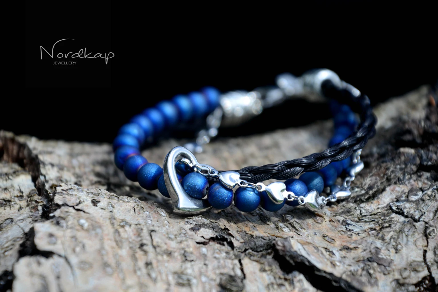 Armband aus Pferdehaar mit dunkelblauen Perlen und Herz auf Rinde