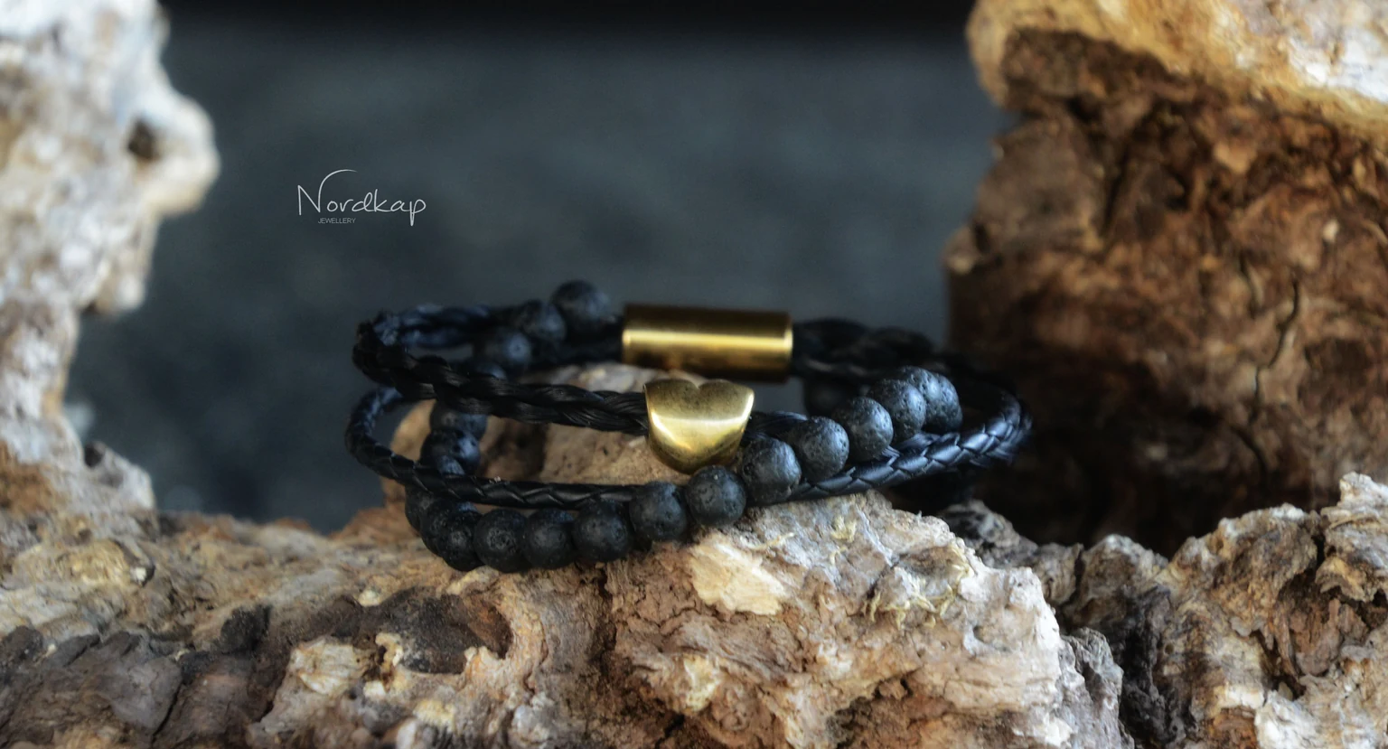 Armband aus schwarzem Pferdehaar mit Lavaperlen, Leder und goldfarbenem Herz auf einem Stein