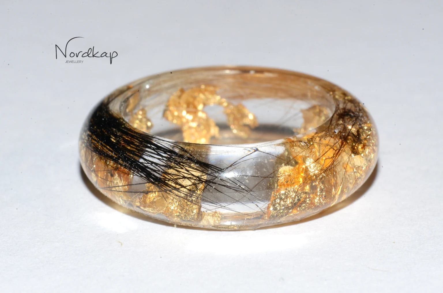 Durchsichtiger Ring mit eingeschlossenem schwarzem Haar und Blattgold