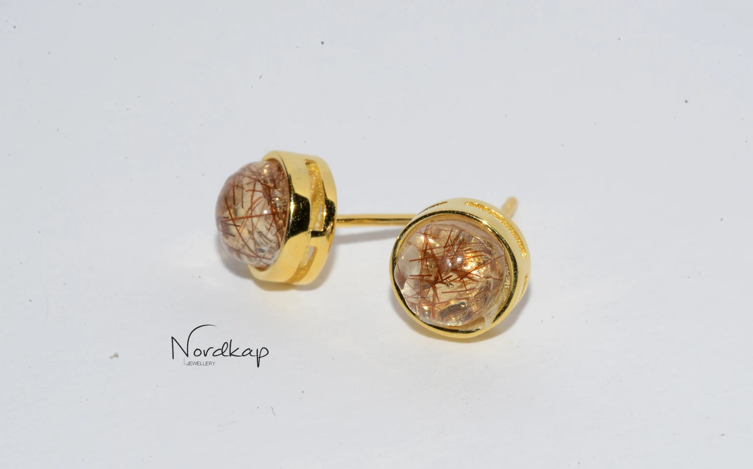 Goldfarbene Ohrstecker mit eingeschlossenem Haar